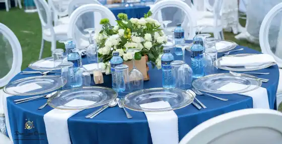 Low angle view of a wedding reception table setting with a white floral centerpiece in a wooden