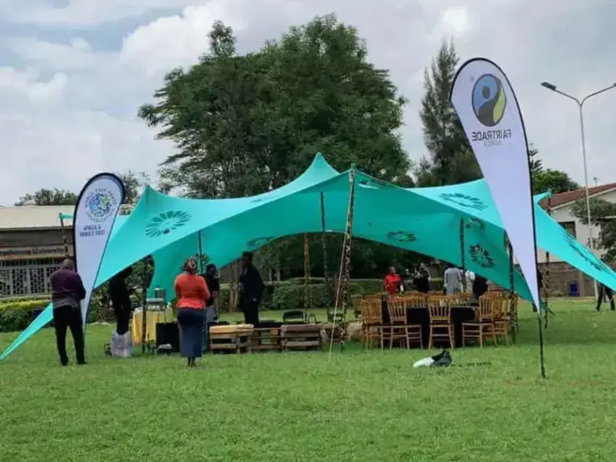 Teal stretch tent set up on a lawn with Britam and Fairtrade Africa banners, hosting an outdoor